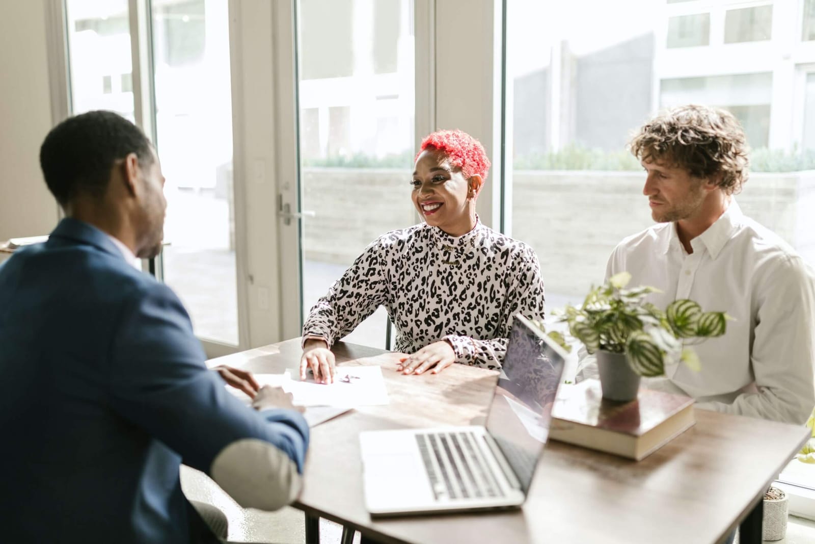 An advisor meeting a couple at a bright table
