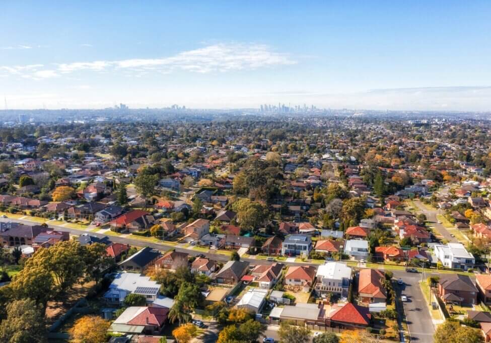 City of Ryde residential suburbs of Greater Sydney in Australia - aerial view towards distant city CBD on horizon.
