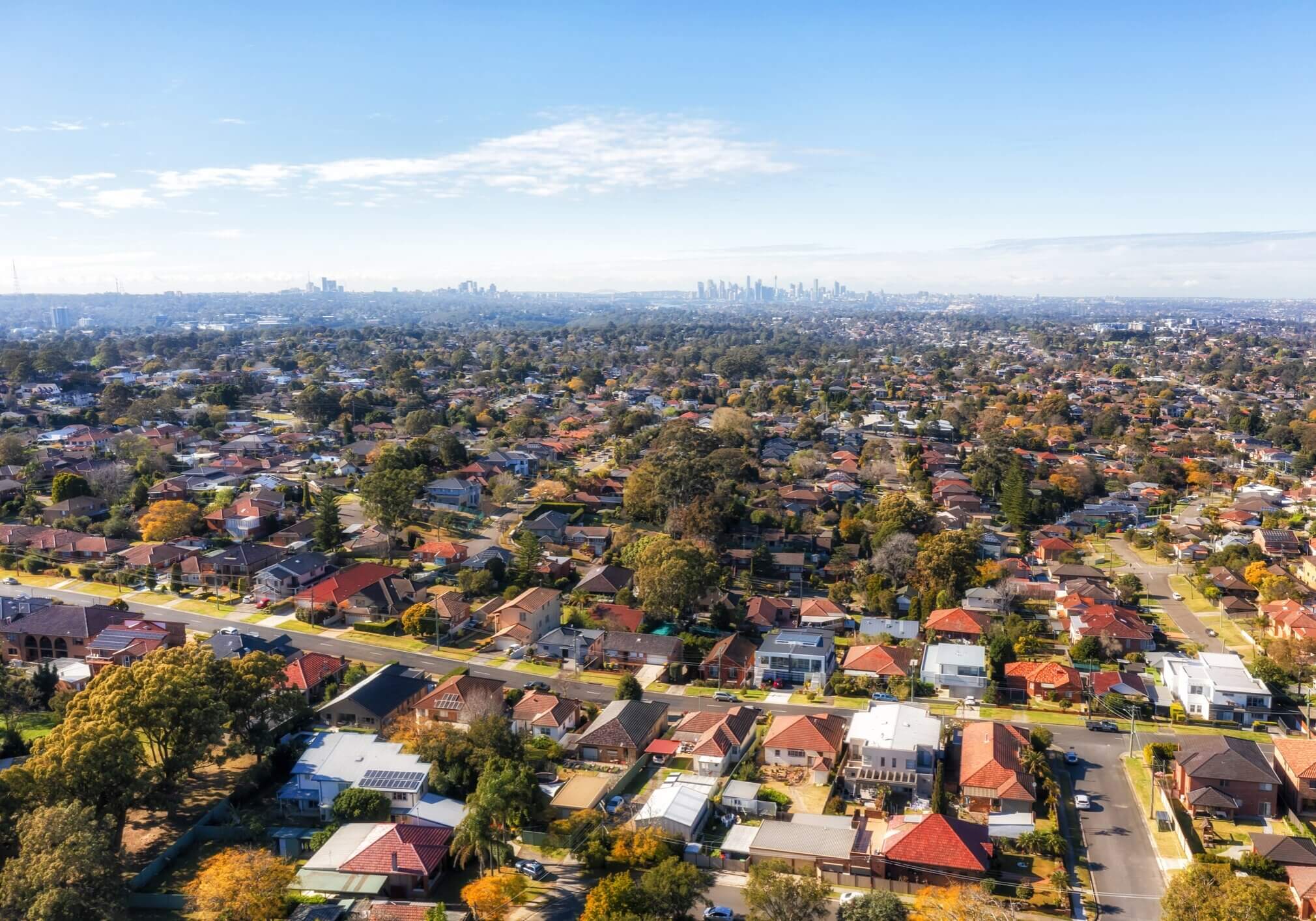 City of Ryde residential suburbs of Greater Sydney in Australia - aerial view towards distant city CBD on horizon.