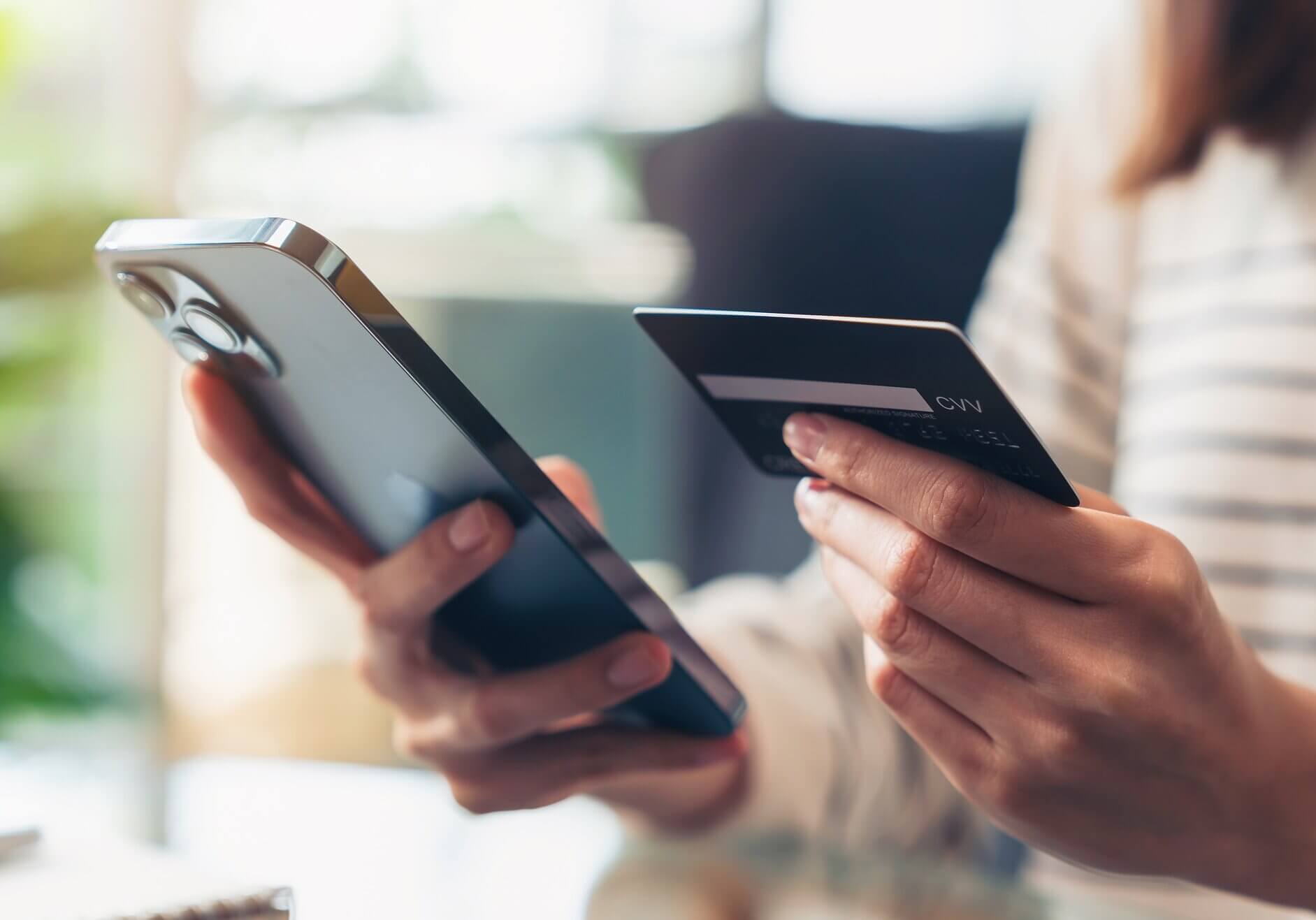 Woman hand holding credit cards and using smartphone for shopping online with payment on internet banking.