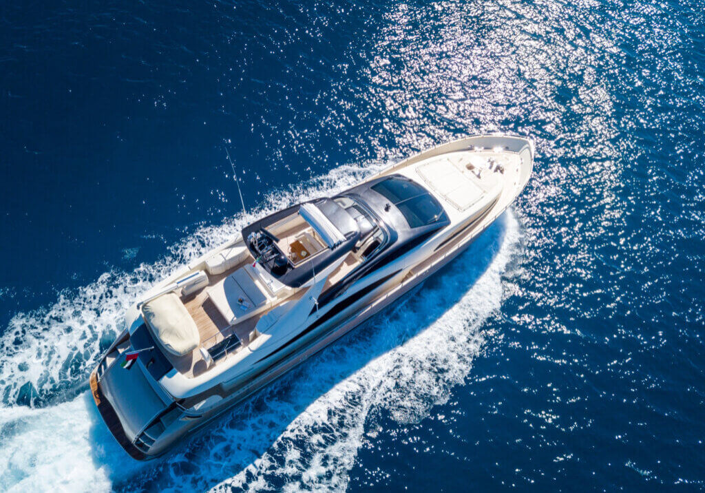 An aerial shot of a yacht sailing on the sea at daytime