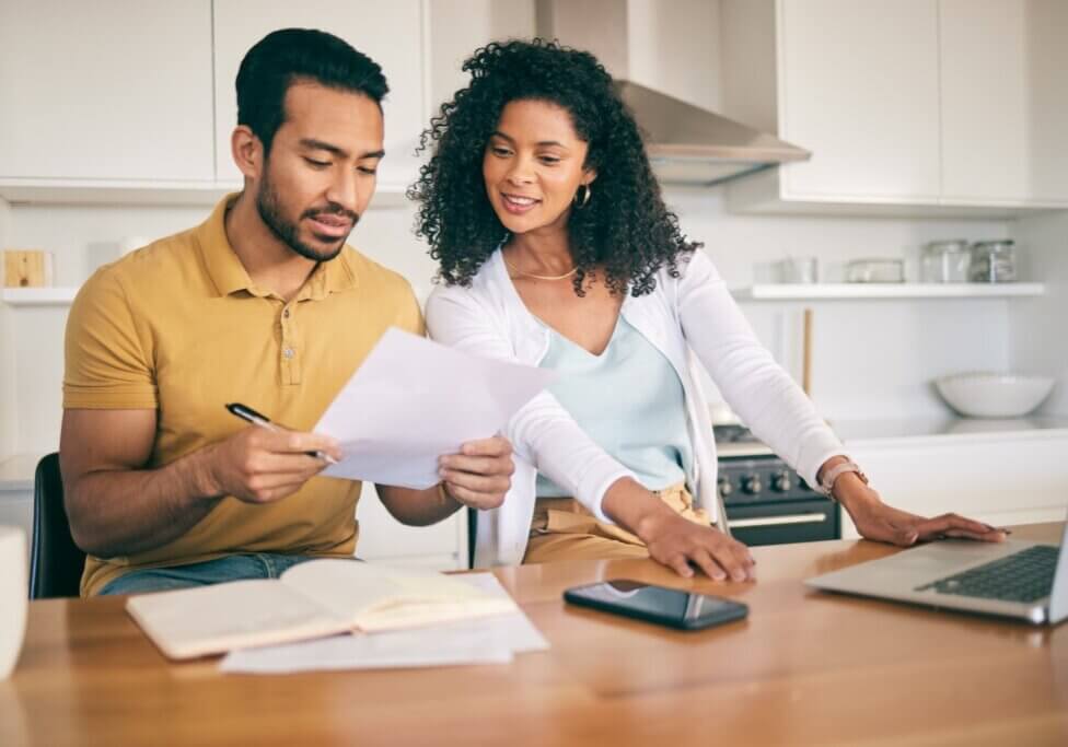 Couple, insurance paperwork and budget planning with laptop, bills and finance with taxes and mortgage. Financial documents, payment and loan with policy, audit and review with asset management
